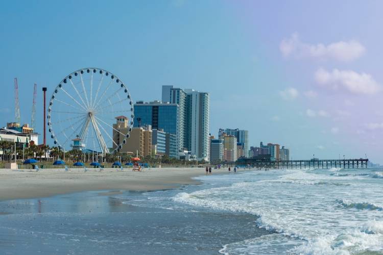 Panoramic view of Myrtle Beach, South Carolina with beach, hotels, ferris wheel, and boardwalk.